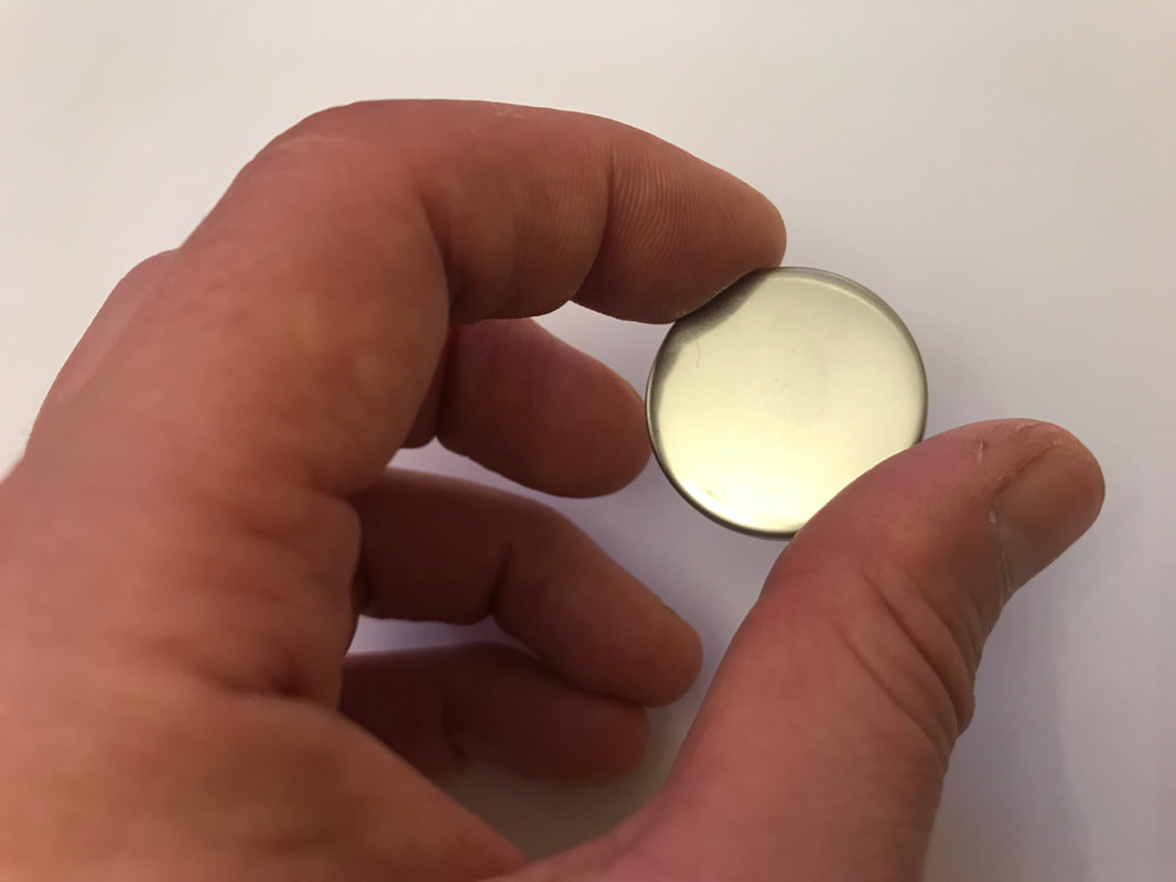 La medalla RA Psi-Generator en plata 925, sostenida en la mano