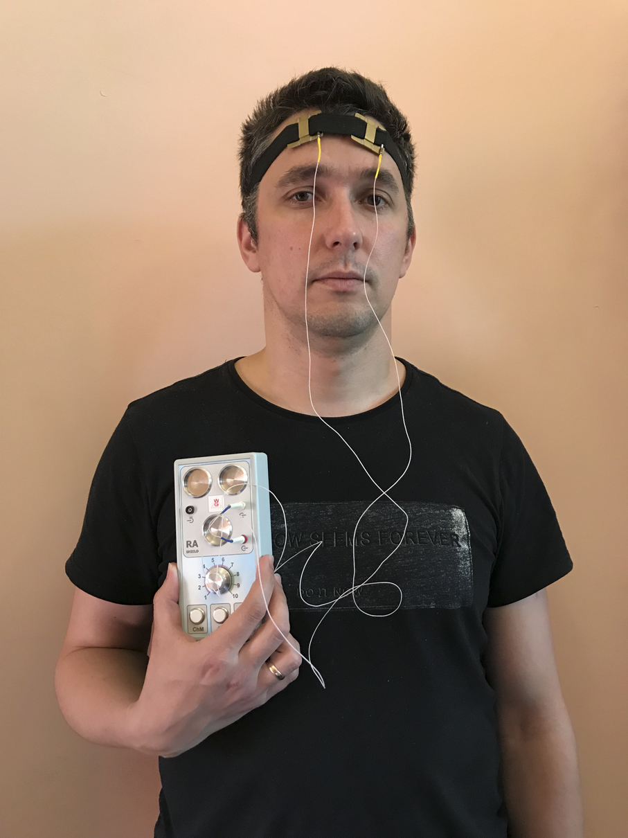 El RA Shield sostenido en la mano, con el electrodo de diadema colocado